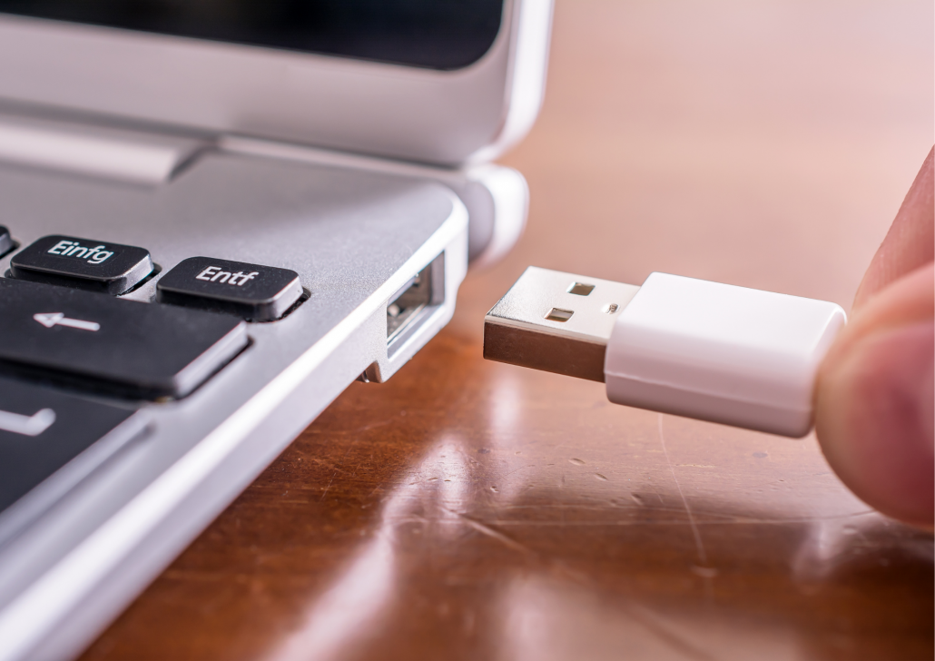 Ein USB-Kabel wird an einem Laptop angeschlossen.